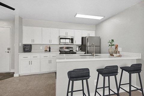 a kitchen with a counter top and three bar stools