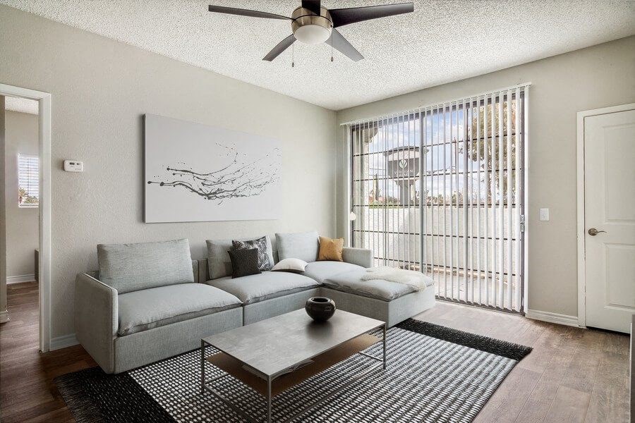 a living room with a couch coffee table and a ceiling fan