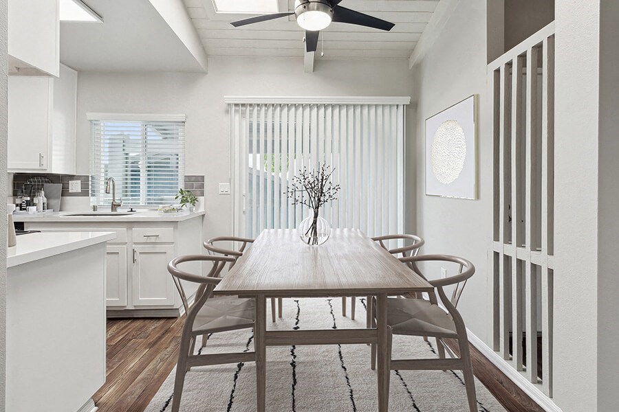 Model Dining Room and Kitchen Area with Wood-Style Flooring and Patio Accessibility at Colonnade at Fletcher Hills Apartments in El Cajon, CA.