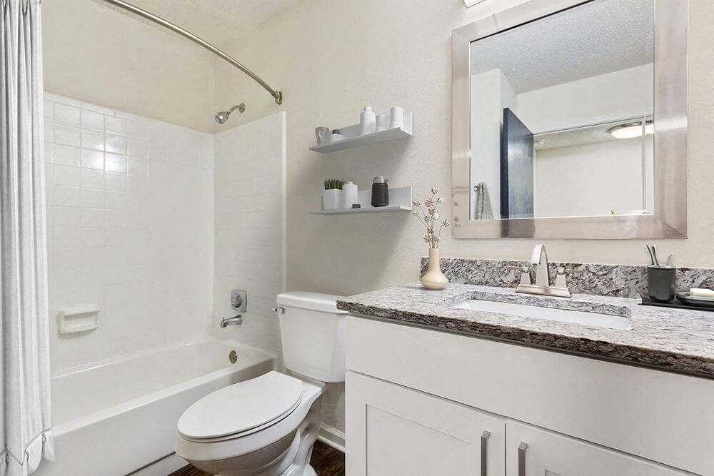 Model Bathroom with White Cabinets, Wood-Style Flooring and Shower/Tub at Grandstand Apartments in Marietta, GA.