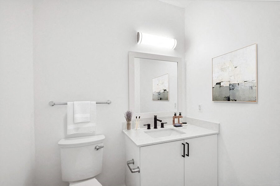 Model Bathroom with White Cabinets, Wood-Style Flooring and Shower/Tub at Stella Apartments located in New Carrollton, MD.
