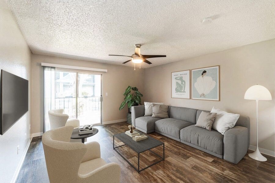 Model Living Room with Wood-Style Flooring and Sliding Glass Door at Indigo Park Apartments in Albuquerque, NM.