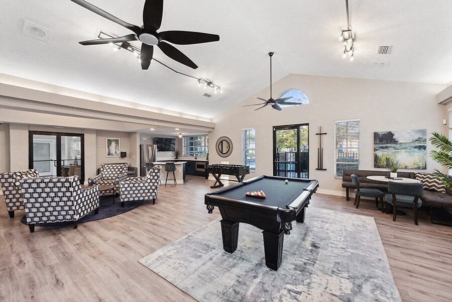 Community Clubhouse with Lounge Furniture and Pool Table Area at Vue at Baymeadows Apartments in Jacksonville, FL.