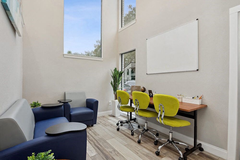 Community Clubhouse with Lounge Furniture and Workstations at Carrollwood Station Apartments in Tampa, FL.