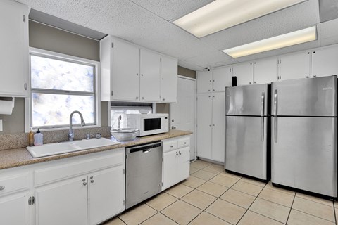 A kitchen with white cabinets and appliances.