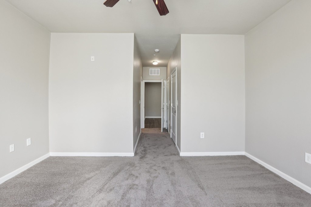 Model bedroom with a carpeted floor and a ceiling fan.