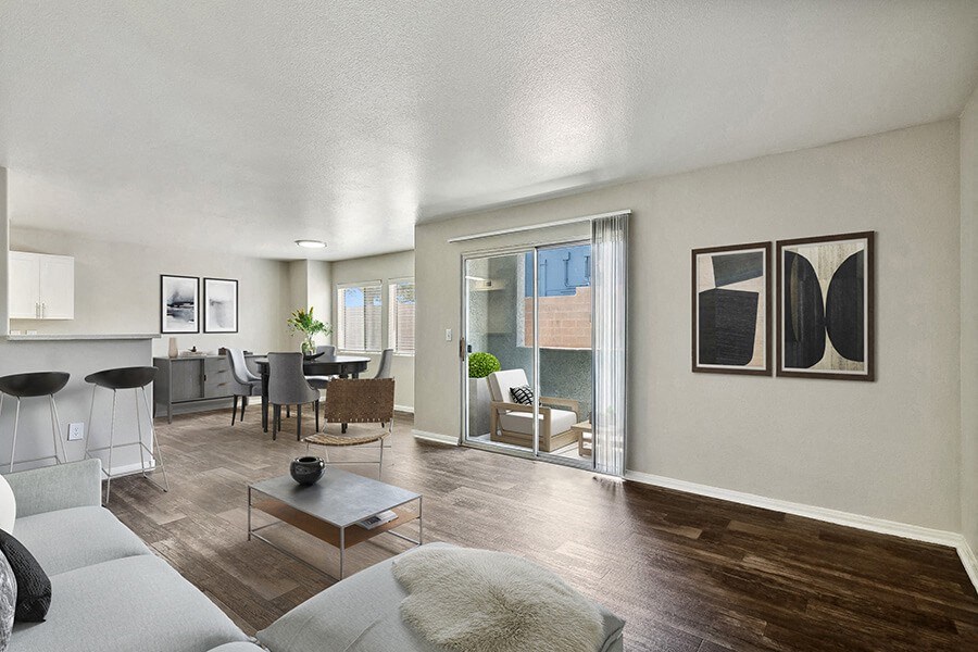 Model Living Room with Wood-Style Flooring, View of Dining Room & Patio Accessibility at Loma Vista Apartments in Las Vegas, NV.