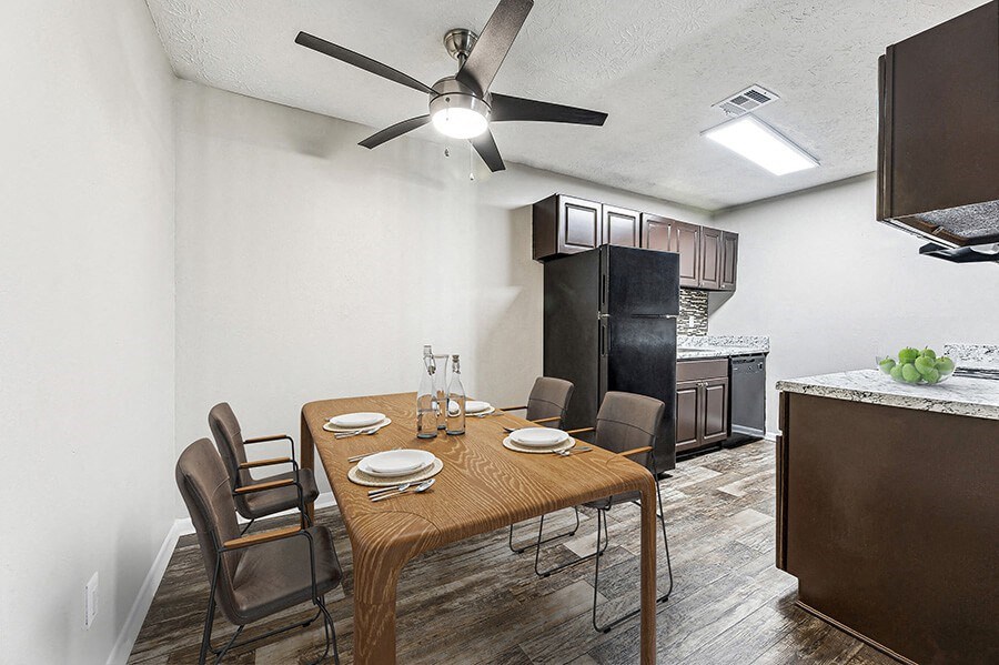 Model Dining Room and Kitchen Area with Wood-Style Flooring at Paramont Apartments in Duluth, GA.