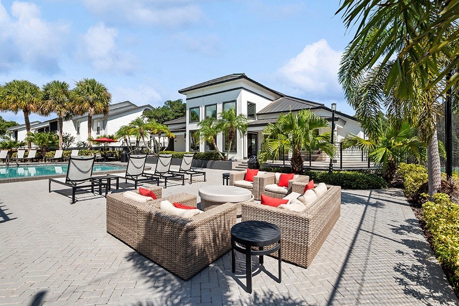 Outdoor Lounge Area with Furniture and View of Pool at Rosehill Preserve Apartments in Orlando, FL.