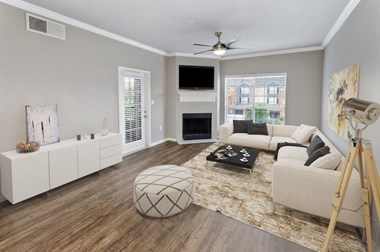Model Living Room with TV above fireplace with patio door and large window