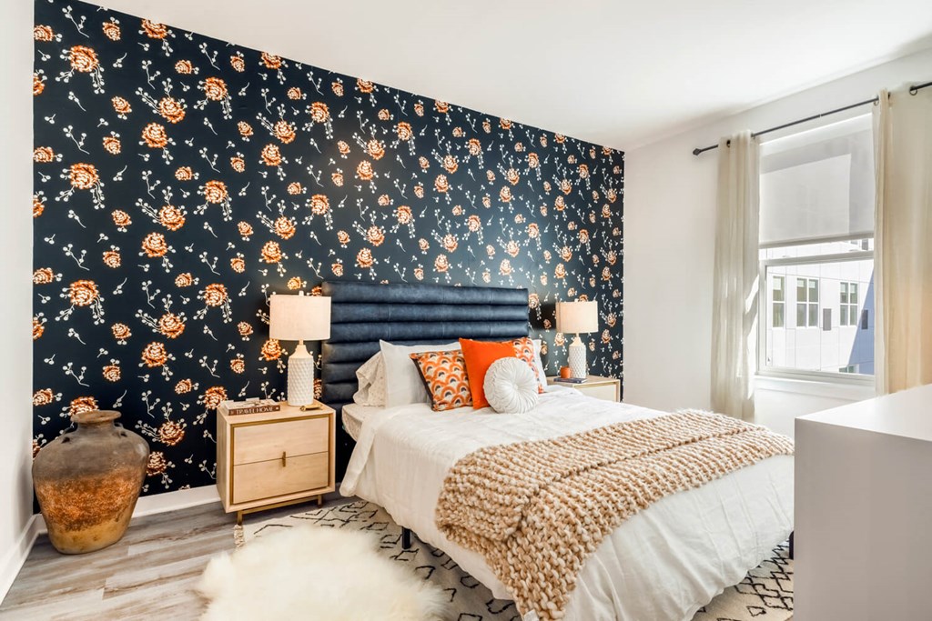 Model bedroom with a bed and a dark wallpaper