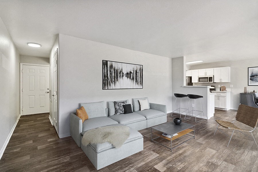 Model Living Room with Wood-Style Flooring, View of Dining Room & Patio Accessibility at Loma Vista Apartments in Las Vegas, NV.