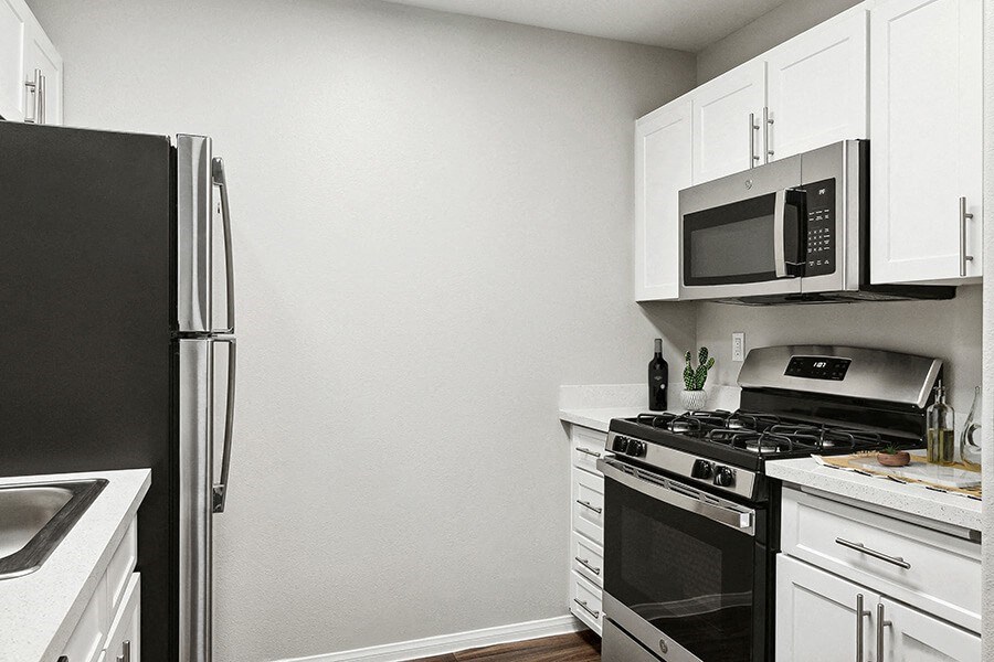Model Kitchen with White Cabinets and Wood-Style Flooring at Loma Vista Apartments in Las Vegas, NV.