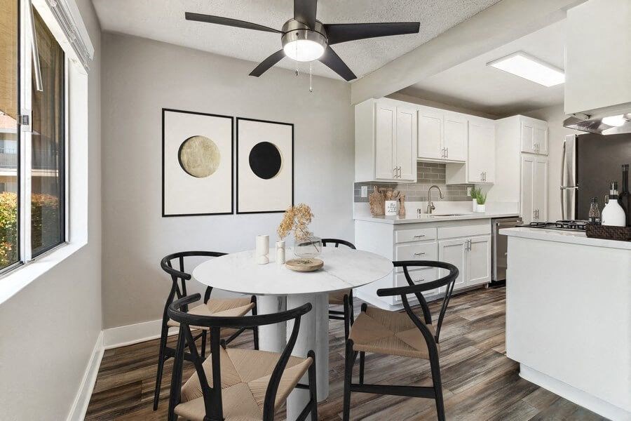 Model Dining Room with Wood-Style Flooring, One Window & View of Kitchen at Forest Park Apartments in El Cajon, CA.