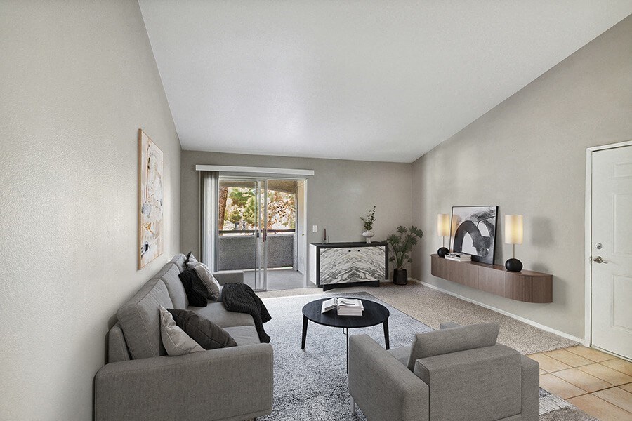 Model Living Room with Carpet and Patio Accessibility at Verraso Apartments in Las Vegas, NV.