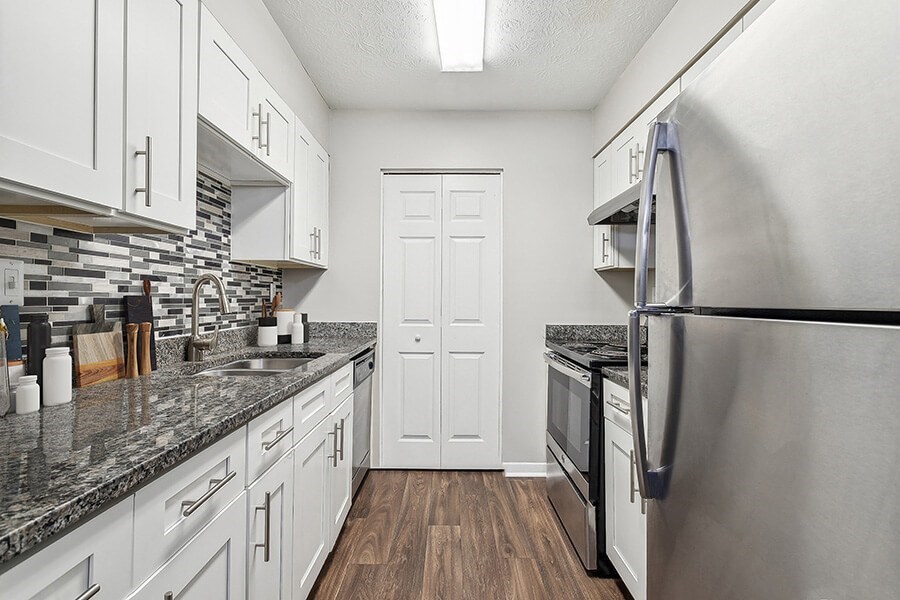 Model Kitchen with White Cabinets and Wood-Style Flooring at Lakeside Retreat Apartments located in Peachtree Corners, GA.