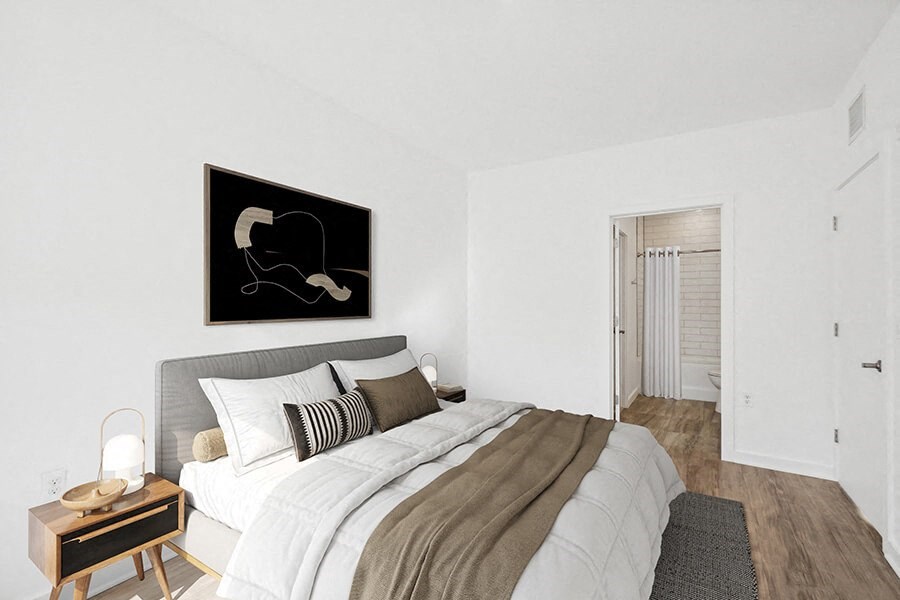 Model Bedroom with Wood-Style Flooring and attached Bathroom at Stella Apartments located in New Carrollton, MD.