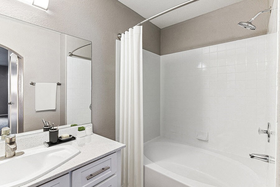Model Bathroom with White Cabinets and Wood-Style Flooring at Topaz Springs Apartments in Las Vegas, NV.