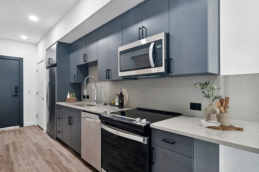 Model kitchen with designer cabinets and stainless steel appliances at Post House North located in Post District Residences in downtown Salt Lake City, Utah