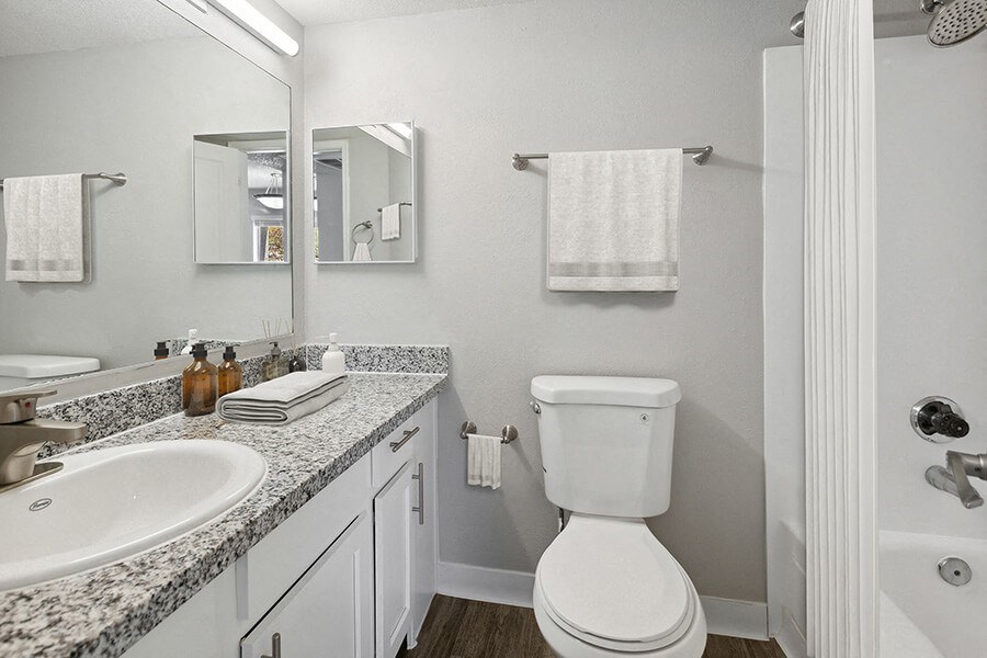 Model Bathroom with Wood-Style Flooring at Hilands Apartments in Tucson, AZ.