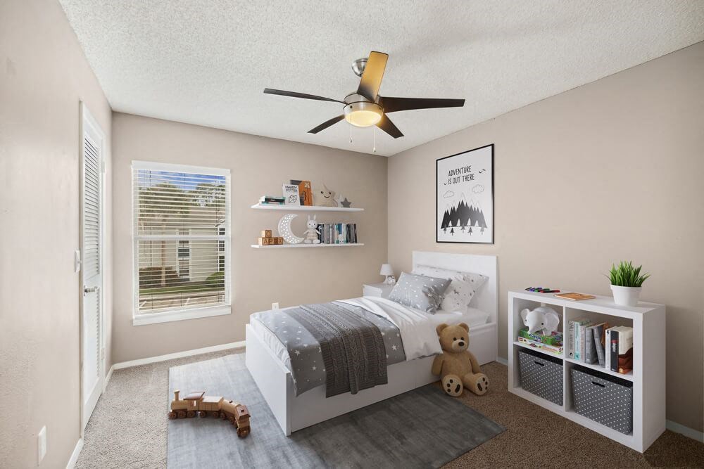 Model bedroom with a bed and a ceiling fan at Vue at Baymeadows Apartments in Jacksonville, Florida