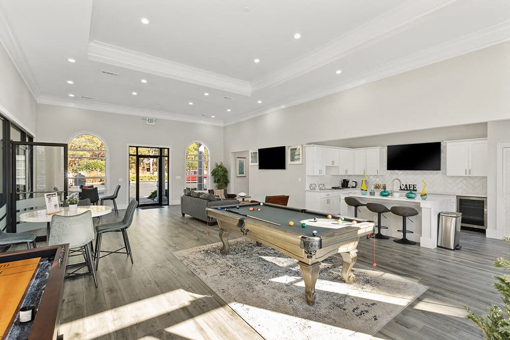 Community Clubhouse with Lounge Furniture and Game Tables at Shadow Ridge Apartments in Riverdale, GA.