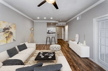 Model Living Room Wood Floors Model Living room with wood floors and kitchen in background - Photo Gallery 4