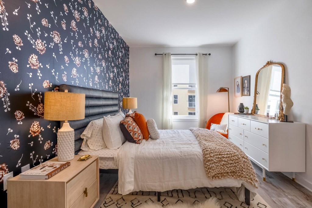 Model bedroom with a bed and blue wallpaper