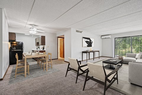 Two-Bedroom Apartments in Burnsville, MN - Elevate on Parkway - A Dining Area With Black Appliances, Wood Table Seating, And Ceiling Fan.