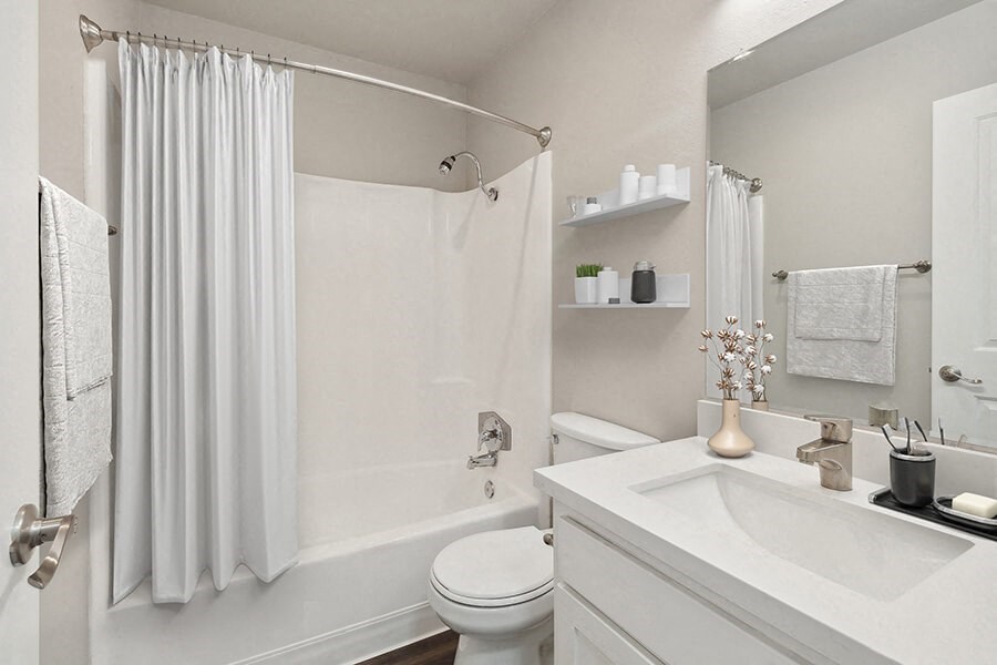 Model Bathroom with White Cabinets, Wood-Style Flooring and Shower/Tub at Colonnade at Fletcher Hills Apartments in El Cajon, CA.