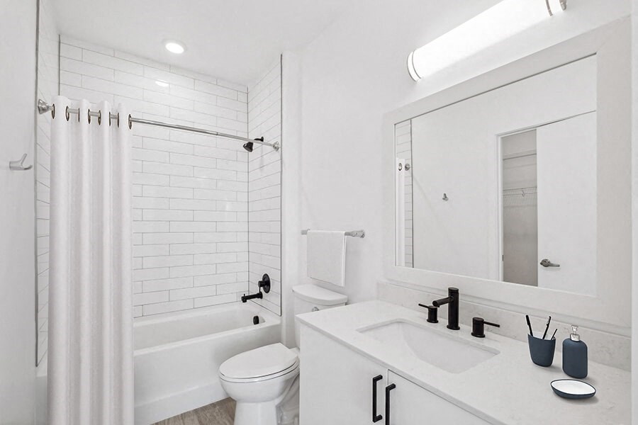 Model Bathroom with White Cabinets, Wood-Style Flooring and Shower/Tub at Stella Apartments located in New Carrollton, MD.