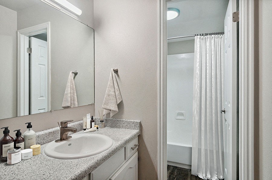 Model Bathroom with White Cabinets & Wood-Style Flooring at Monaco Apartments in Salt Lake City, UT.