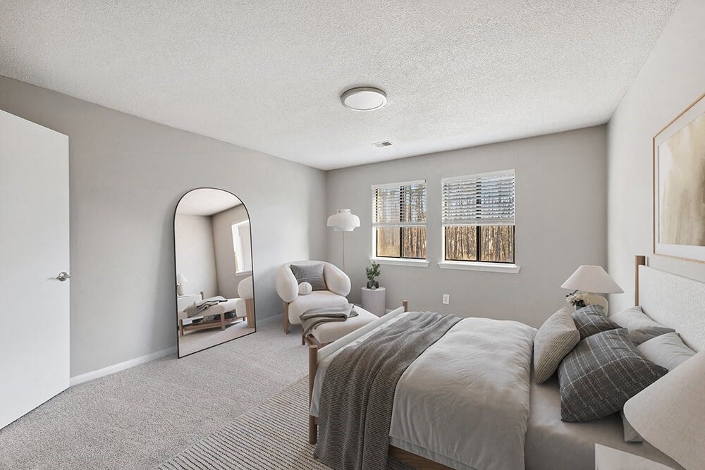 Model Bedroom with Carpet and Window View at Spring Forest Apartments in Raleigh, NC.