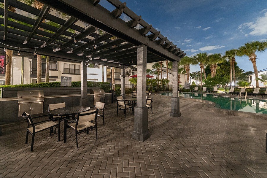 Outdoor BBQ Area with Canopy and View of Pool at Rosehill Preserve Apartments located in Orlando, FL.