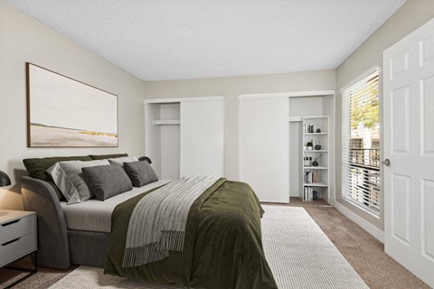 Model apartment bedroom with a large bed and a large window at Villages at Metro Center, Arizona