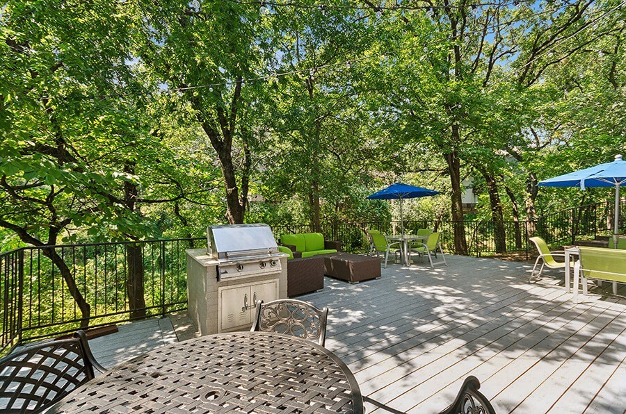 Outdoor Patio with Lounge Furniture & BBQ Grills at Woodcreek Apartments located in Arlington, TX.