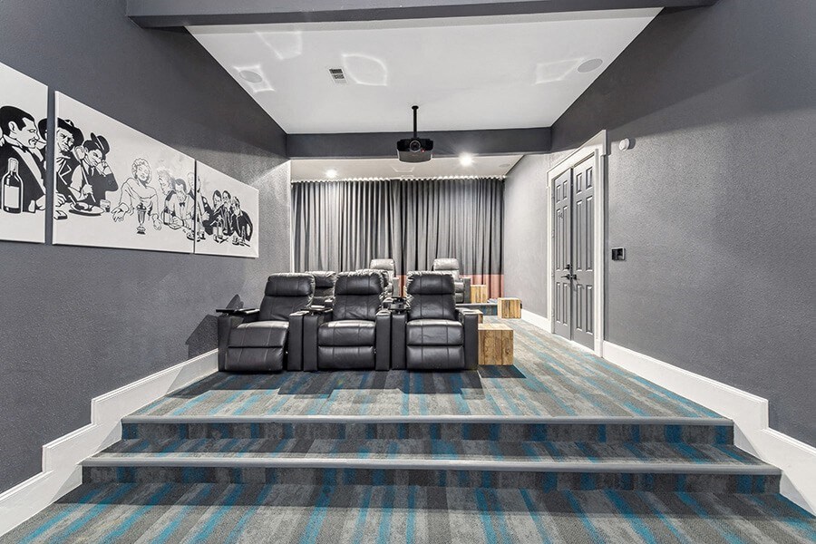 Community Theater Room with Lounge Chairs and Projector Screen at Chapel Hill Apartments located in Lewisville, TX.