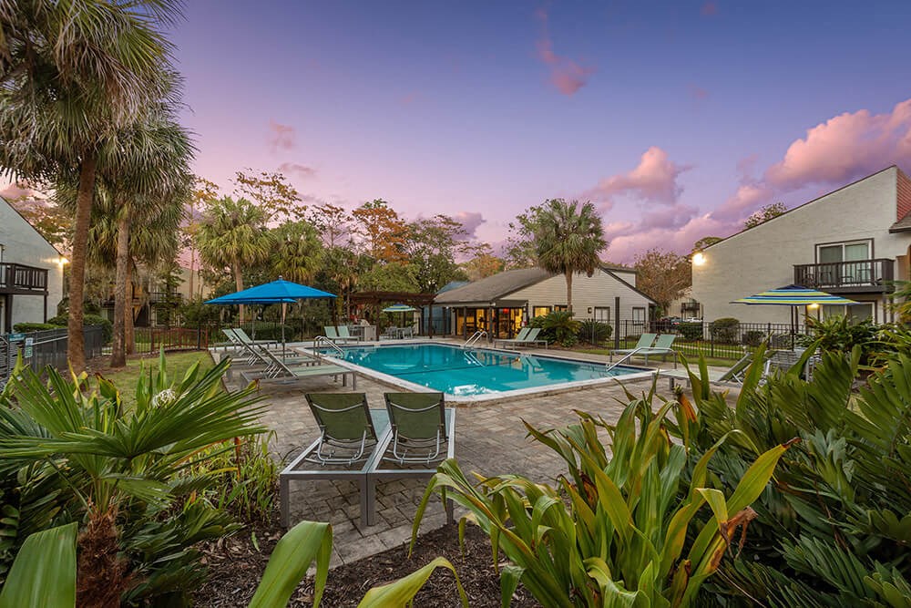 Community Swimming Pool with Pool Furniture at Heron Walk Apartments in Jacksonville, FL.