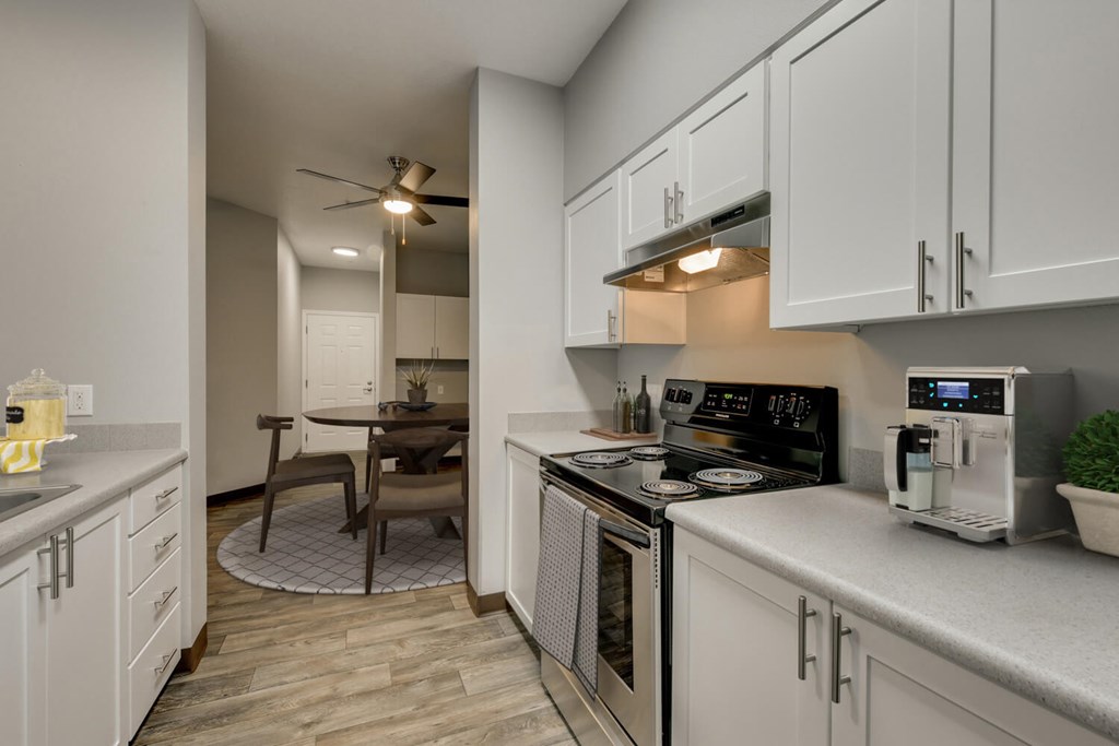 Model Kitchen with White Cabinets and Wood-Style Flooring at Landings at Morrison Apartments located in Gresham, OR.