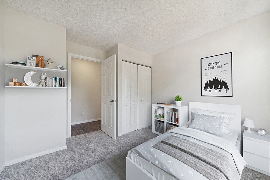 Model Bedroom with Carpet and Hallway View at The Commons at Haynes Farm Apartments in Boston, MA.