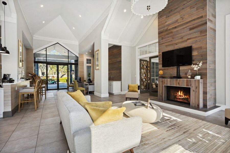 Clubhouse Lounge Area with Fireplace and View of Kitchen at Caribbean Breeze Apartments in Tampa, FL.