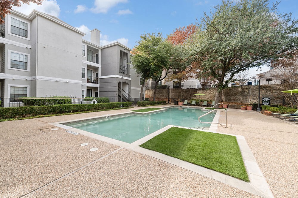 Community Swimming Pool with Pool Furniture at Bridges at Oakbend Apartments in Lewisville, TX.