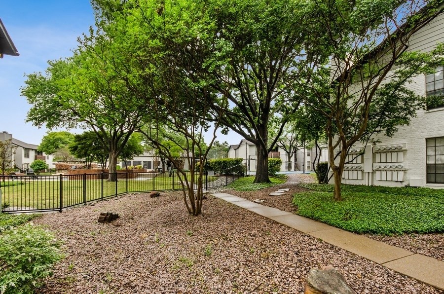 Apartment courtyard with trees and a fence