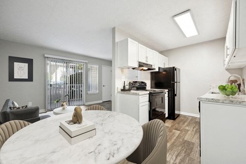 a kitchen and a dining room with a table and chairs