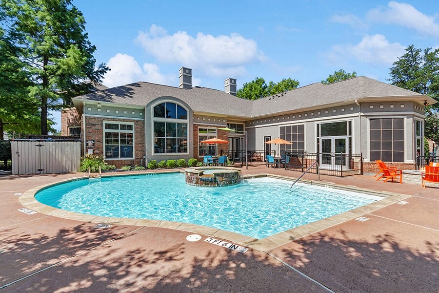 Community Swimming Pool with Pool Furniture at Belmont at Duck Creek Apartments in Garland, TX.