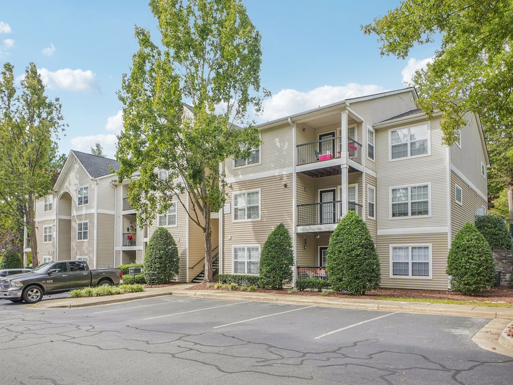 A large apartment building with a parking lot in front.