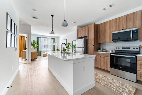 A modern kitchen with wooden cabinets and a white island.