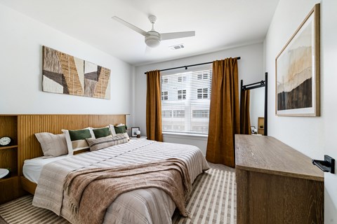 A bedroom with a large bed and a wooden headboard.