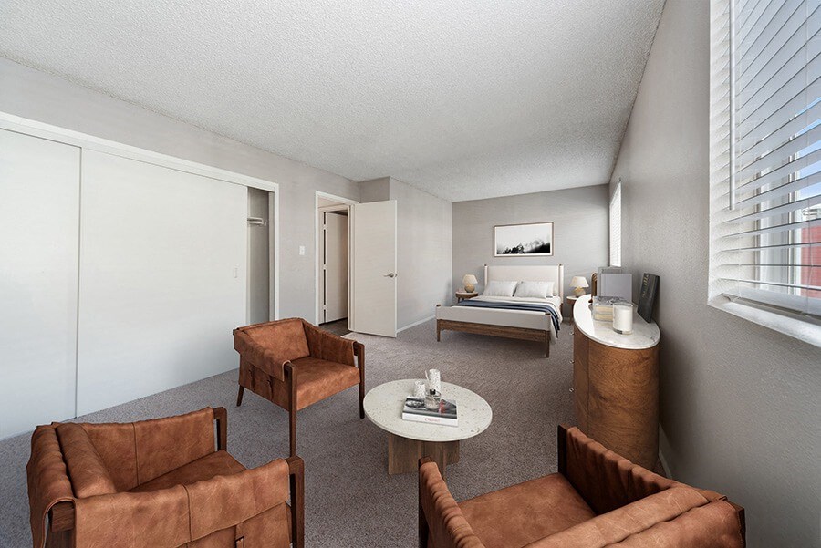 Model Living Room with Carpet, Double Closets and Window View at Bridges at 9 Mile Station Apartments in Denver, CO.