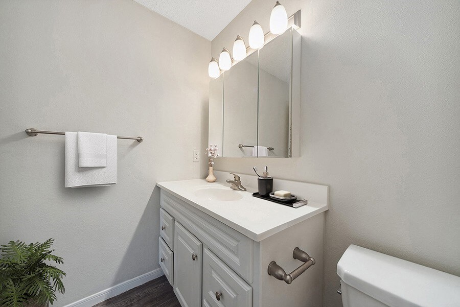 Model Bathroom with White Cabinets and Wood-Style Flooring at The Commons at Haynes Farm Apartments in Boston, MA.